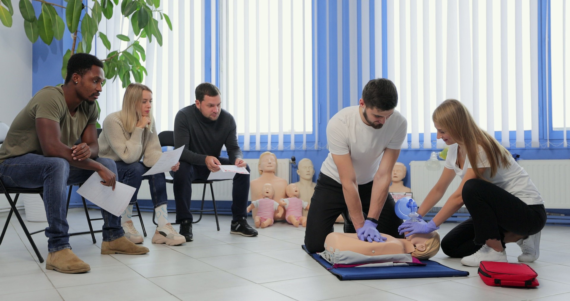 Männlicher Lehrer, der seinen Schülern Erste-Hilfe-Cpr-Technik beibringt.